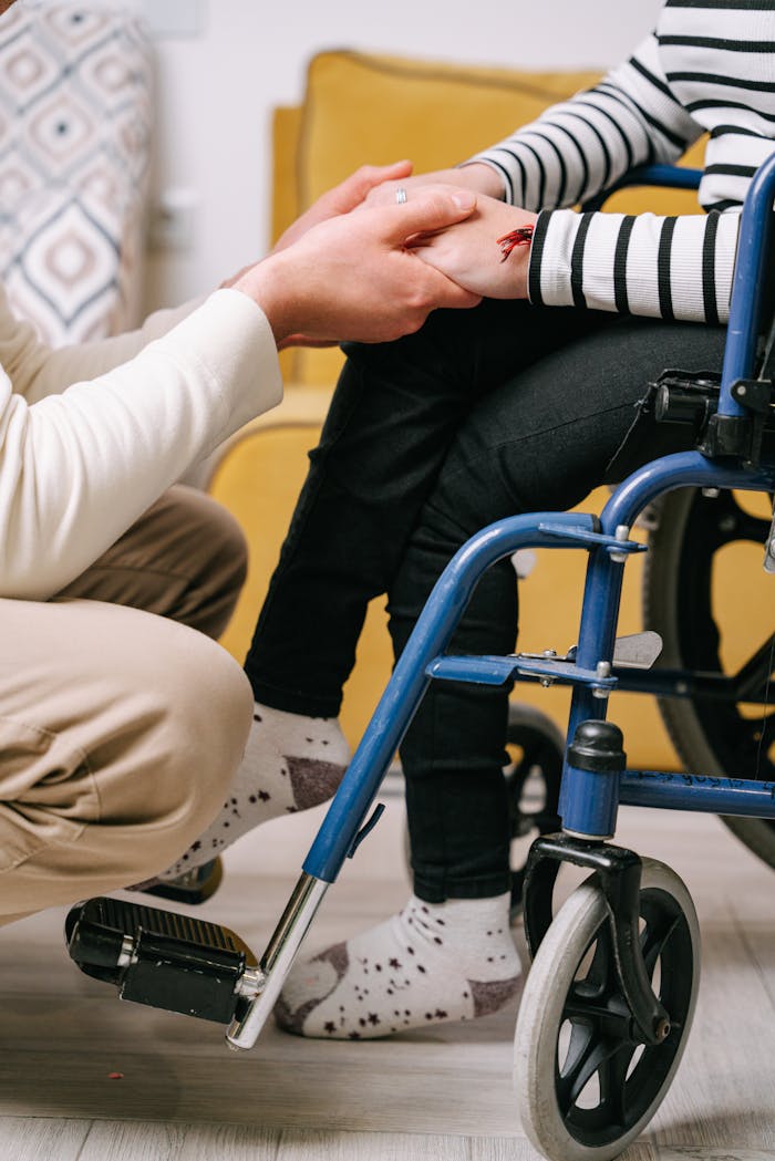 Home Supportive interaction between caregiver and wheelchair user, showing compassion.